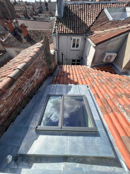 Verrière Velux installée avec entourage en zinc à tasseaux et tuiles  canal